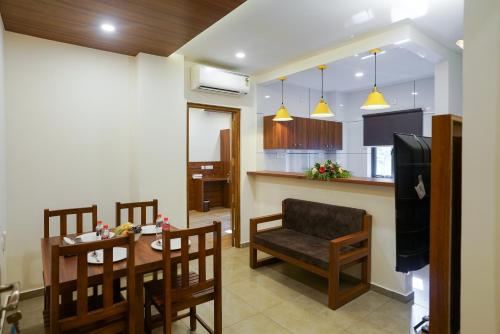 a kitchen and living room with a table and chairs at Grand Apartments in Kottakkal