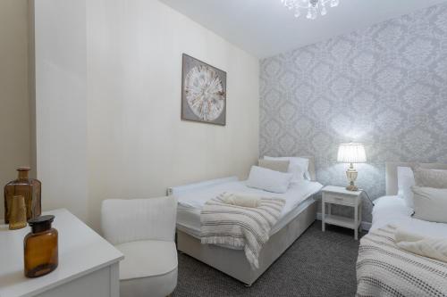 a white room with a bed and a chair at Mount Eagle - Sleeps 24 in Limerick