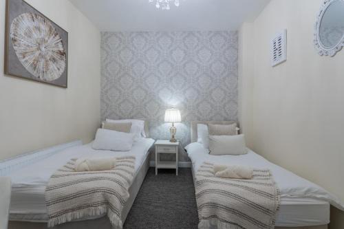 a white room with two beds and a lamp at Mount Eagle - Sleeps 24 in Limerick