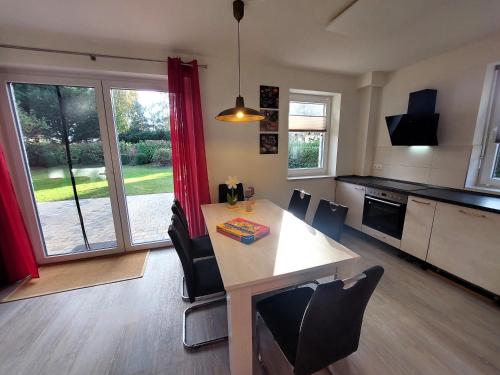 a kitchen with a table and chairs and a large window at Ferienhaus "Unser neues Haus" in Trassenheide