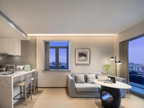 上海市にあるSomerset Pudong Riverside Shanghaiのソファとテーブルのあるキッチンとリビングルーム