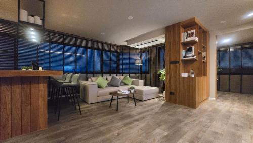 a living room with a couch and a table at ARMO Nimman 2 Suite in Chiang Mai