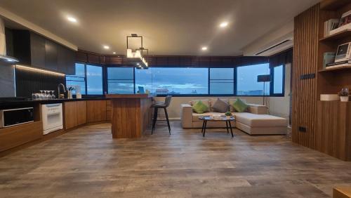 a kitchen and living room with a couch and a table at ARMO Nimman 2 Suite in Chiang Mai