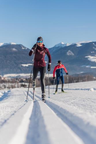 two people are cross country skiing in the snow at Ariala Apartments in Falzes