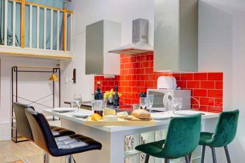 une cuisine avec un comptoir avec des chaises vertes et une table dans l'établissement Bluestay 108 - Superb apartment in Paris, à Paris