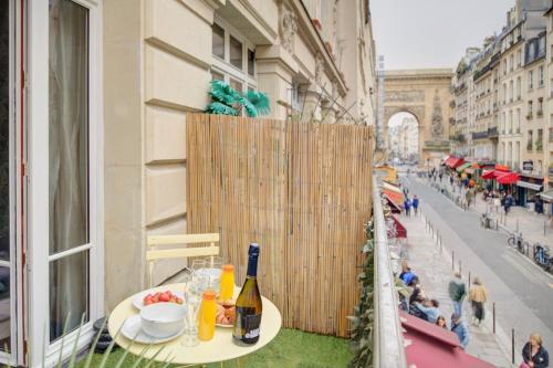 - une table avec une bouteille de vin sur le balcon dans l'établissement Bluestay 108 - Superb apartment in Paris, à Paris
