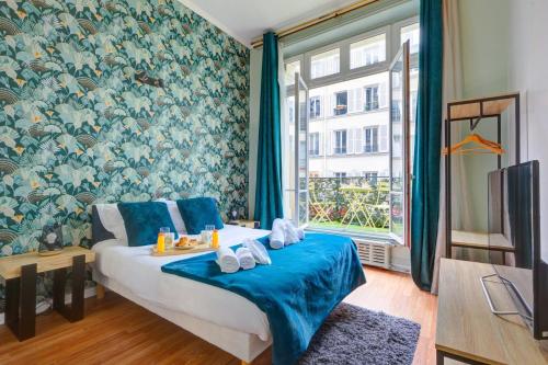 une chambre avec un lit avec des draps bleus et une fenêtre dans l'établissement Bluestay 108 - Superb apartment in Paris, à Paris