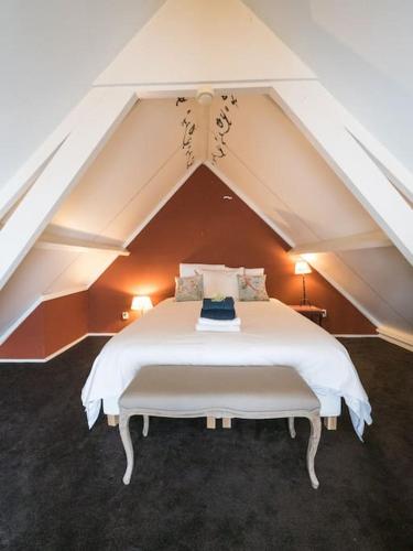 a bedroom with a white bed in an attic at Hosted by wendy Old city charming accommodation in Wassenaar