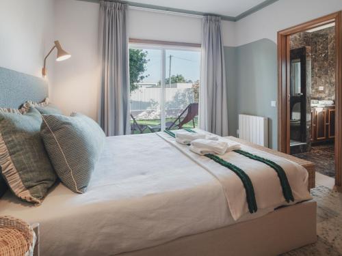 a bedroom with a large bed with a window at BeSunny Slowness n' Outdoors in Esmoriz