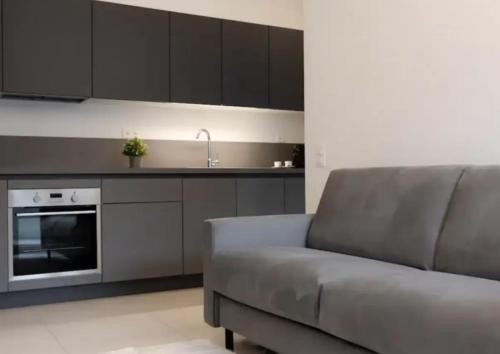 a living room with a couch and a kitchen at Urban Residence by Quokka 360 - Apartments with parking in Lugano in Aldesago