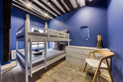 Cette chambre bleue comprend des lits superposés et une chaise. dans l'établissement Beautiful fully renovated apartment - Near Paris, à Pierrefitte-sur-Seine