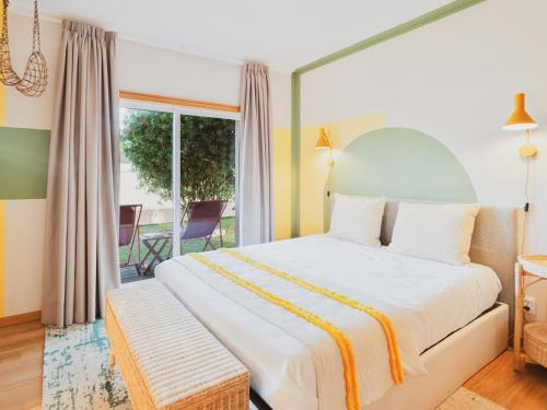 a bedroom with a large bed and a balcony at BeSunny Slowness n' Outdoors in Esmoriz