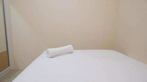 a white bed with a white towel on it at Elegant and Spacious 3BR at Bale Hinggil Apartment By Travelio in Medokanayu