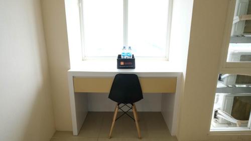 a desk with a chair in front of a window at Elegant and Spacious 3BR at Bale Hinggil Apartment By Travelio in Medokanayu