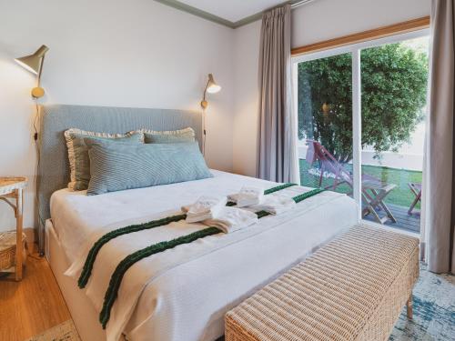 a bedroom with a large bed with towels on it at BeSunny Slowness n' Outdoors in Esmoriz