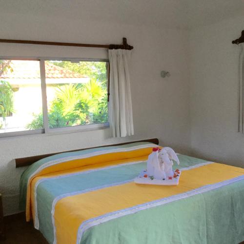 a bedroom with a bed with a stuffed elephant on it at Hotel Club Akumal Caribe in Akumal