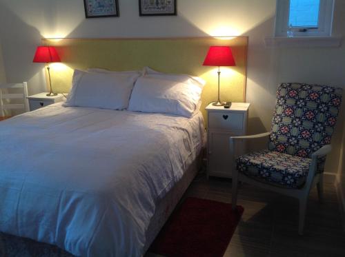 a bedroom with a bed and a chair and two lamps at Saorsa House Culross in Fife