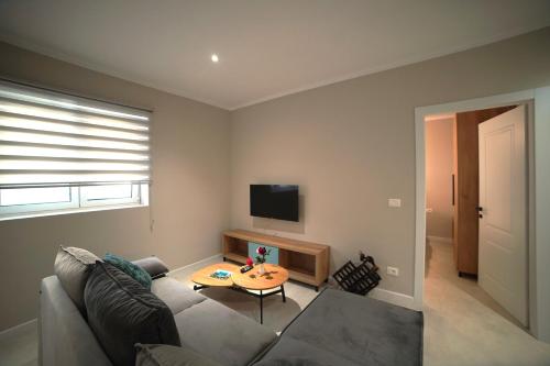 a living room with a couch and a table at Center Oasis Appartmens in Tirana