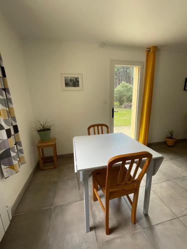 une table blanche et deux chaises dans une pièce dans l'établissement L'Olympe, à Brantes