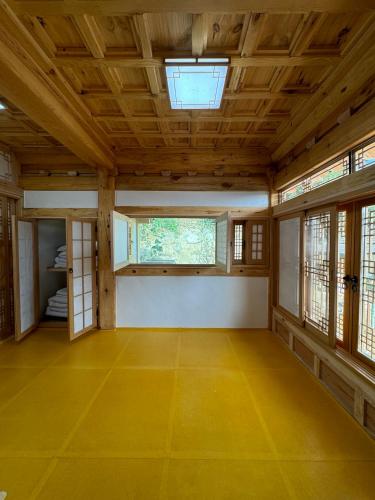 an empty room with a wooden ceiling and windows at Hanok Stay - JukRokJungSa in Gurye