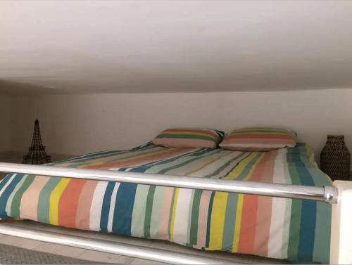 - un lit avec des draps rayés et 2 oreillers dans l'établissement Studio Nice Centre 4P Jean médécin avenue, à Nice