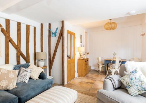 a living room with a couch and a table at Windsor Cottage - Bolthole in the heart of CN! in Chipping Norton