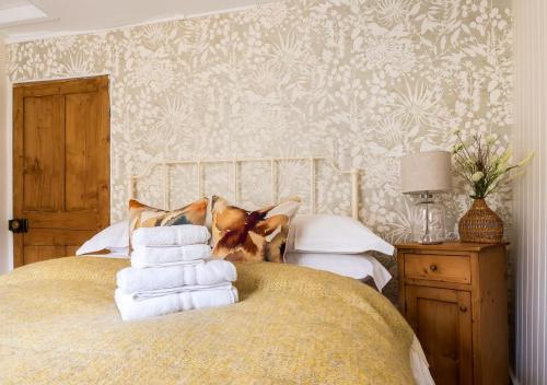 a bedroom with a bed with white towels on it at Windsor Cottage - Bolthole in the heart of CN! in Chipping Norton