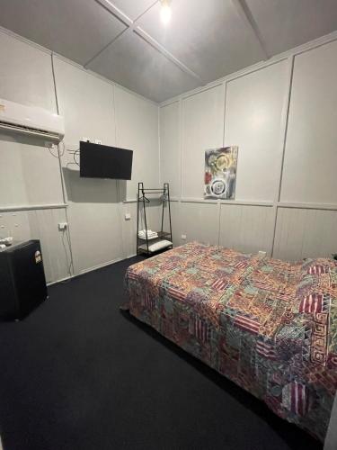 a bedroom with a bed and a flat screen tv at Hotel Thangool in Thangool