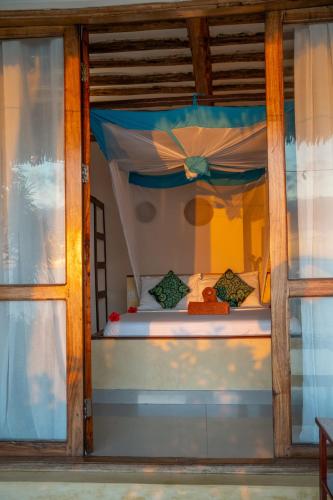 a bedroom with a bed with a canopy at Mnana Beach Bungalows in Michamvi