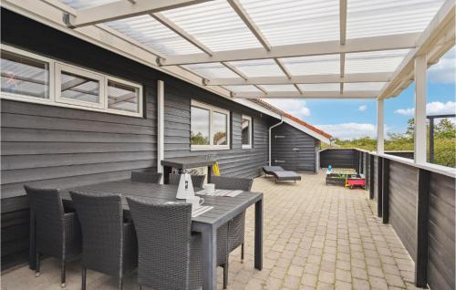 an outdoor patio with a table and chairs at Holiday Home Jordbærvej Tarm Iv in Hemmet