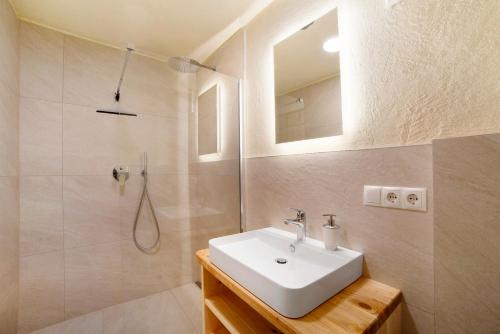 a bathroom with a sink and a shower with a mirror at Hauserhof in Lagundo