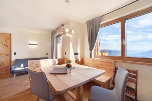 a dining room with a table and chairs and a couch at Hauserhof in Lagundo