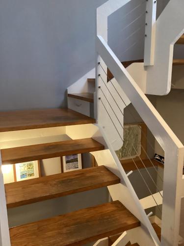 a white staircase with wooden treads and wooden floors at Classic Stowe Ski Chalet chalet in Stowe
