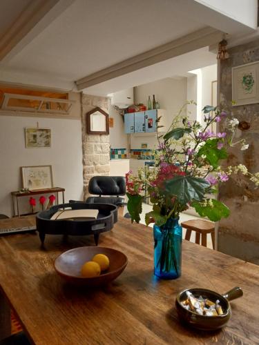 - un salon avec une table en bois et un vase de fleurs dans l'établissement Stipologic 6P 2BR, à Paris
