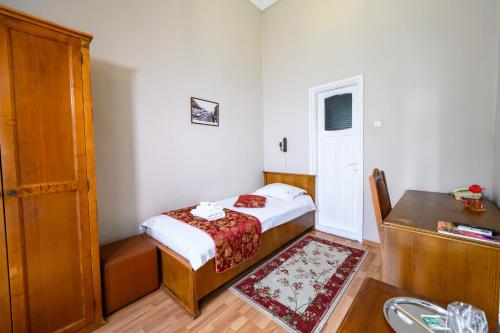 a small bedroom with a bed and a desk at Hotel Transilvania in Cluj-Napoca