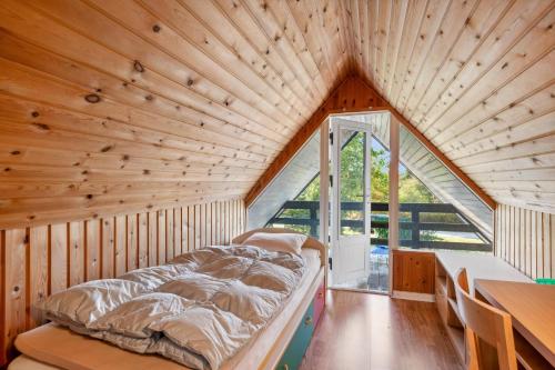 a bed in a room with a wooden ceiling at Charming Older House In A Scenic Natural Area in Glesborg
