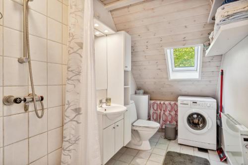 a small bathroom with a toilet and a washing machine at Charming Older House In A Scenic Natural Area in Glesborg