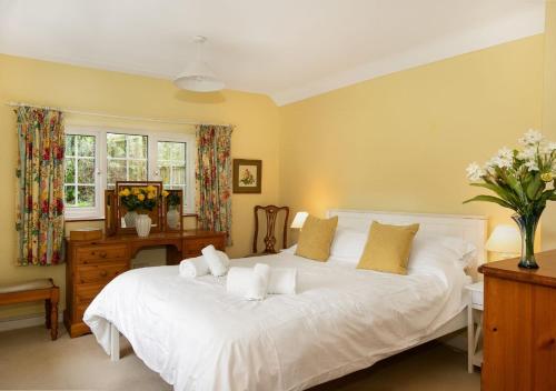 Woodcutter's Cottage - Peaceful Country Retreat! في Over Worton: غرفة نوم بسرير ابيض كبير وبجدران صفراء