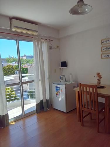 a kitchen with a table and a refrigerator and a window at Alquiler Balcarce in Rosario