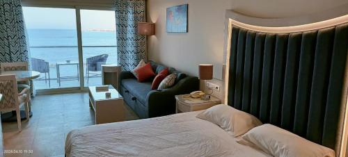a bedroom with a bed and a couch and a window at Beau Site Belle Vue Hotel in Marsa Matruh