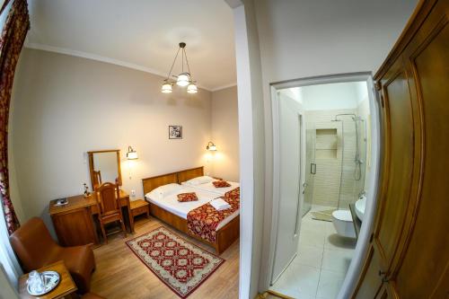 a bedroom with a bed and a bathroom with a shower at Hotel Transilvania in Cluj-Napoca
