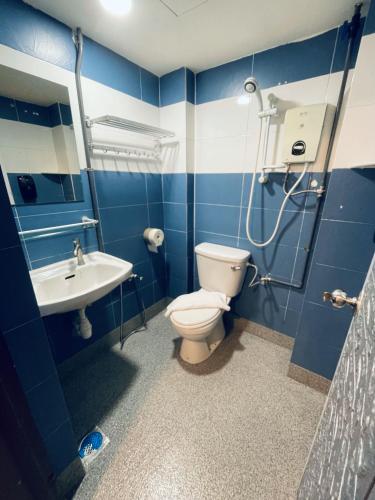 a blue bathroom with a toilet and a sink at De Swift Hotel in Malacca