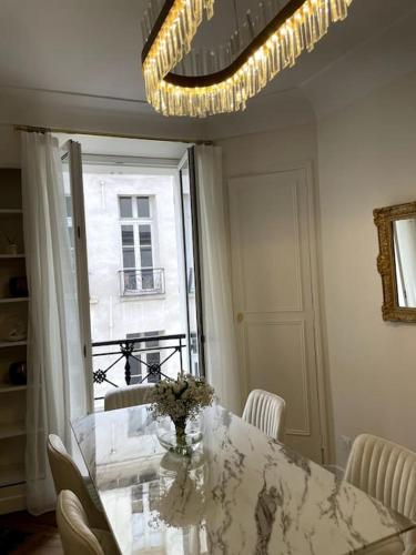 une salle à manger avec une table, des chaises et un lustre dans l'établissement Paris Luxury Family Getaway, à Paris