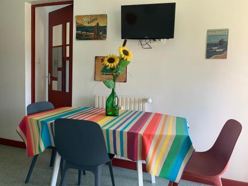 une table colorée avec un vase de tournesols sur elle dans l'établissement HOSTA Piscine Vue Montagnes, à Souraïde
