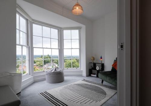 グレート・マルバーンにあるCosy 1BD in Malvern With Stunning Views!のリビングルーム(大きな窓、緑のソファ付)