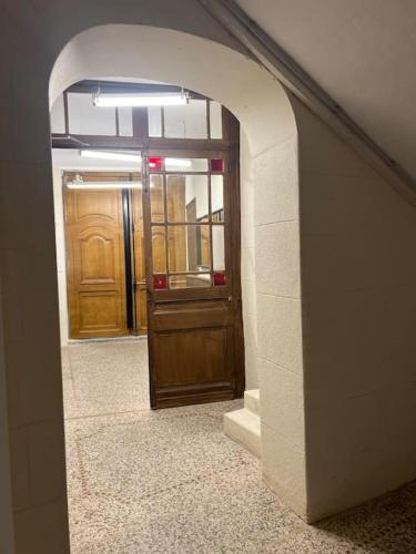 une arche dans un couloir avec une porte en bois dans l'établissement Tylkostudio - Le Corner, à Montpellier