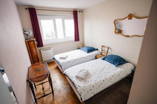 deux lits dans une petite pièce avec une fenêtre dans l'établissement Eiffel Tower, à Paris