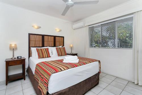 a bedroom with a large bed and a window at On Palm Cove Beachfront Apartments in Palm Cove