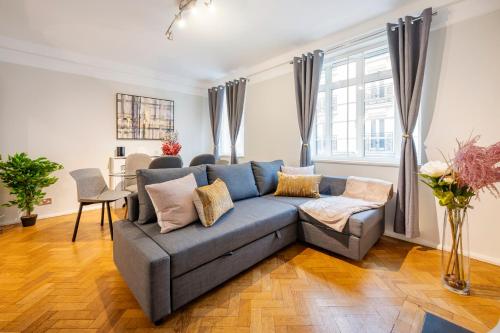 a living room with a blue couch and a table at Welcome London Buckingham Palace in London