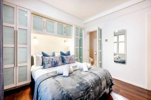 a bedroom with a large bed with blue pillows at Welcome London Buckingham Palace in London